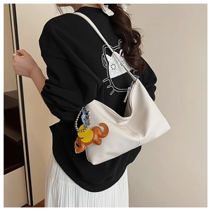 Close-up of off-white lychee grain leather hobo bag with cute brown elephant charm