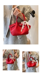 Detail of red lychee grain leather bucket bag featuring lace bow and pearl charm