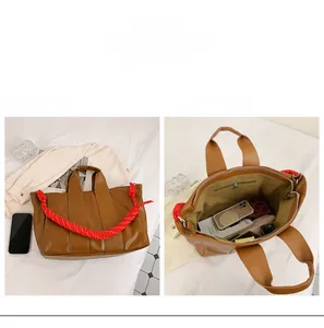 Detailed interior of brown leather tote bag with large capacity and red rope handle