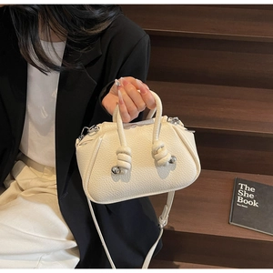 Dettaglio borsa in pelle martellata bianco crema con manico a corda annodata di design