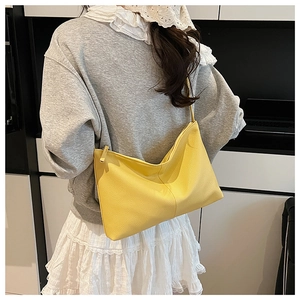 Detail of soft yellow lychee grain leather crossbody bag with a focus on texture