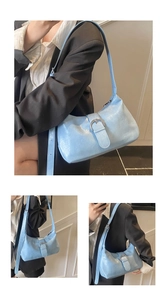 Three-way view of light blue wrinkled faux leather underarm bag with silver metal buckle