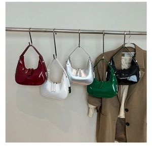Collection of shiny patent leather hobo bags in five colors hanging on a metal bar