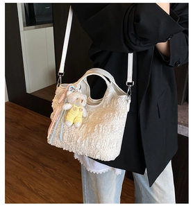 Détail du sac cabas blanc en tissu gaufré avec breloque ours et accents de cordes colorées