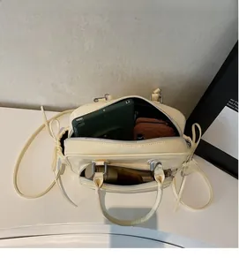 Top view of open cream leather handbag showing spacious compartments for tablet and wallet