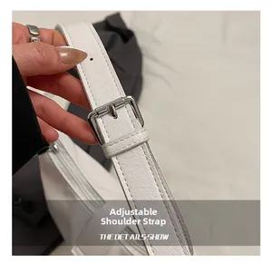 Detail view of the white leather shoulder bag with adjustable strap and silver metal buckle