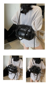 Detail of glossy black patent leather handbag featuring zippers and adjustable shoulder straps