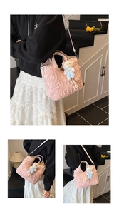 Gros plan sur un sac cabas plissé rose avec pendentif ours blanc et bandoulière