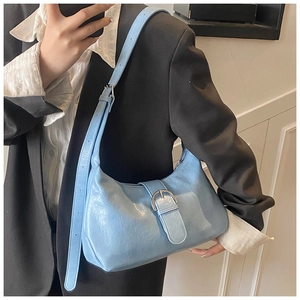 Detail of light blue hobo bag showing faux leather texture and silver buckle