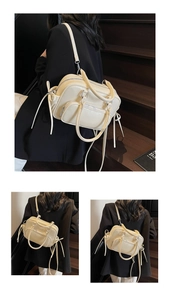 Detail of cream multi-pocket leather bag showing tassel zipper and adjustable strap