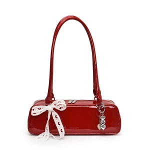 Red patent leather baguette shoulder bag with white lace bow and heart charms stylish.