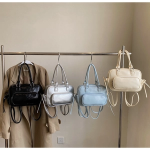 Boston style handbags in four colors displayed on a rack with multi-functional straps