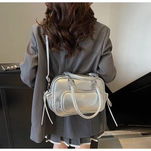 Silver metallic Boston bag with pebble texture and drawstring detail on model
