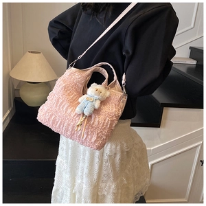 Détail du sac seau plissé rose avec breloque ours en peluche et bandoulière amovible