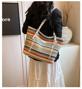 Detail view of colorful woven tote bag with silver leather strap and metal eyelet accents