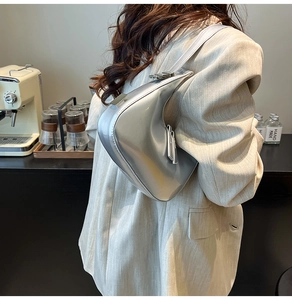 Silver mirror crescent bag shown as a shoulder bag in a stylish lifestyle setting