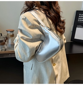 Sac sous le bras argenté en forme de croissant avec blazer beige pour un style chic