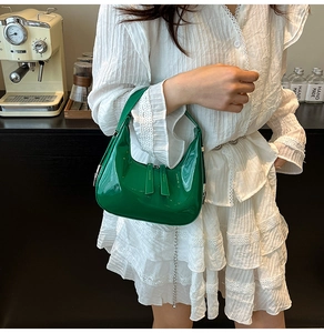 Détail du sac croissant en cuir verni vert émeraude avec chaîne et double fermeture