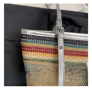 Macro shot of silver metallic buckle and colorful woven straw material on beach tote