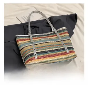 Detail of colorful striped woven tote bag with silver handle and metal buckle on fabric