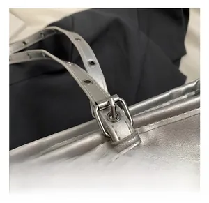 Detail of adjustable silver metallic strap with polished buckle and metal eyelets