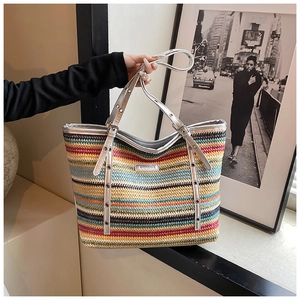 Detailed macro view of colorful striped woven tote with metallic eyelets and silver logo plate