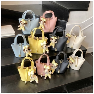Detailed close-up of colorful litchi pattern bucket bags with cute puppy charms