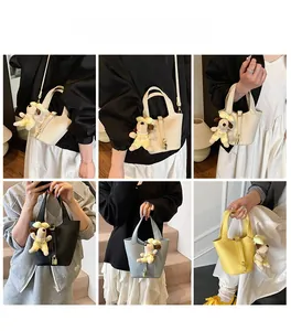Detail view of lychee pattern leather bucket bags with cute puppy charms in various colors