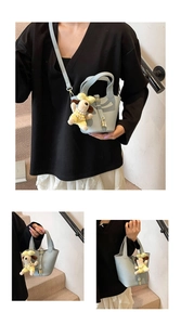 Detailed view of light blue lychee pattern bucket bag with cute yellow dog charm