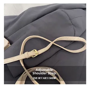 Detail of adjustable litchi texture leather strap with a gold metal buckle on bucket bag