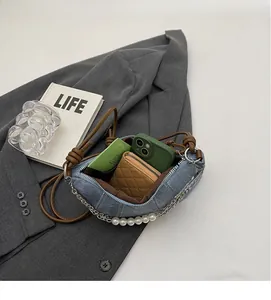 Interior view of denim shoulder bag showing large capacity for phone and wallet