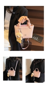 Pink bucket bag with knotted handle detail and cute teddy bear charm on dark wood stairs