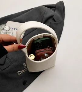 Detail van witte leren emmertas met binnenruimte voor een smartphone en portemonnee