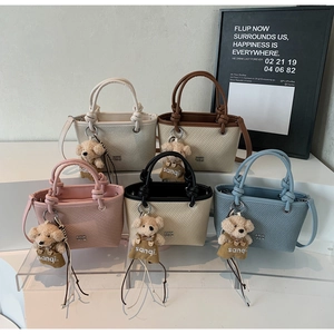 Detailed view of woven texture crossbody bags in five colors with cute bear charms
