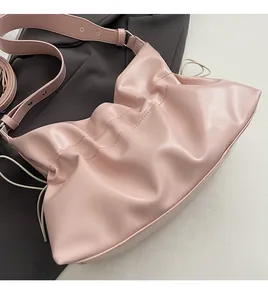 Détail du sac fourre-tout rose plissé en simili cuir avec large bandoulière et cordon