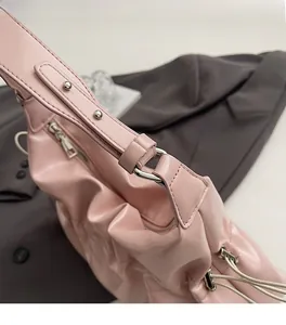 Gros plan d'un sac cabas en cuir rose avec ferrures argentées et plis texturés