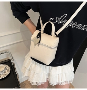 Mini borsa a scatola crema trama litchi e ciondolo a cuore indossata con gonna di pizzo