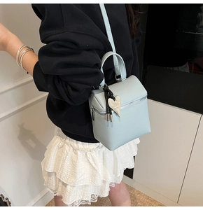 Dettaglio borsa in pelle azzurra con ciondolo a cuore argento e zip in metallo