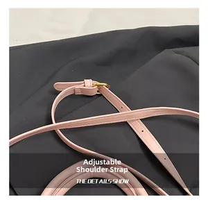 Dettaglio borsa in pelle rosa con tracolla regolabile e fibbia in metallo oro