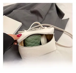 Detailed interior of lychee pattern handbag holding a wallet and makeup cushion