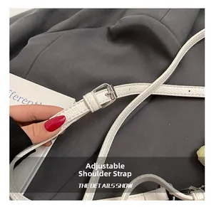 Detail of adjustable white lychee grain leather shoulder strap with silver buckle