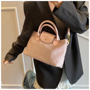 Dettaglio borsa tote rosa chiaro con trama in tessuto, manico in pelle e ganci oro