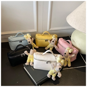 Detail of lychee pattern leather box bags with Snoopy plush charms in five soft colors