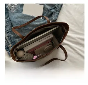 Macro view of a brown tote bag showing large capacity for laptop, books and essentials
