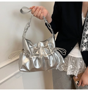 Détail d'un sac nuage plissé argenté métallisé avec des accents de cordon blanc