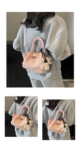 Détail du sac seau rose tressé avec breloque fleurie et bandoulière amovible