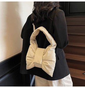 Chic ballet-style bow tote bag in off-white quilted fabric shown on a female model