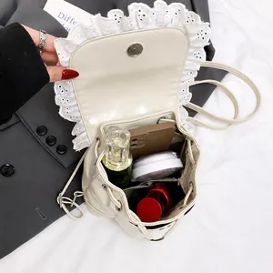 Detail of cream mini backpack interior showing space for phone, perfume, and makeup