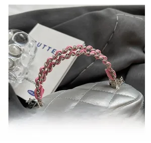 Dettaglio della trama trapuntata argento con catena in metallo e pelle rosa