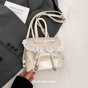 Detail view of cream white PU backpack featuring lace trim and bowknot accents